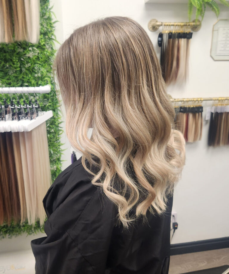 Woman with long ombre wavy hair with extensions, seen from the side